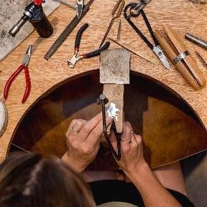 Student crafts unique necklace at the bench in silver jewellery making workshop
