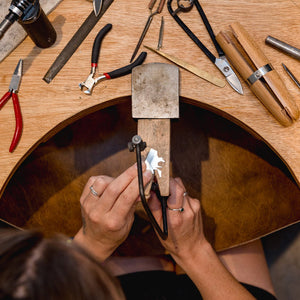 Student crafts unique necklace at the bench in silver jewellery making workshop