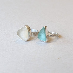 Examples of silver and sea glass and stone rings made by students in silver making jewellery workshop