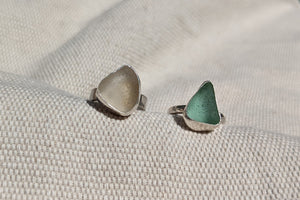 Examples of silver and sea glass and stone rings made by students in silver making jewellery workshop