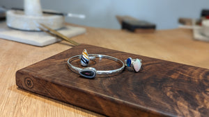 Examples of handcrafted silver and stone rings and bracelet made in jewellery making workshop