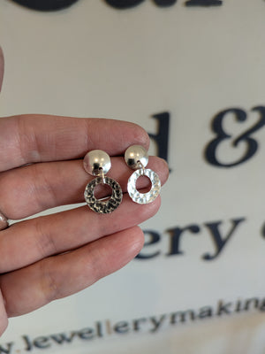 Student shows handcrafted silver earrings made in jewellery making workshop