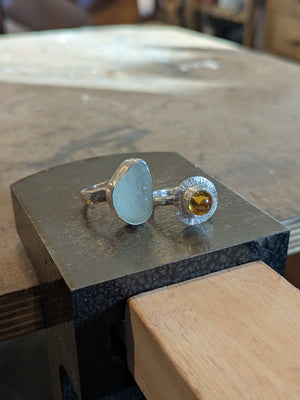 Examples of handmade sea glass and stone rings made in silver jewellery making workshop
