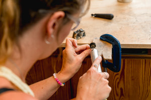Student polishes handcrafted silver piece made in jewellery making workshop