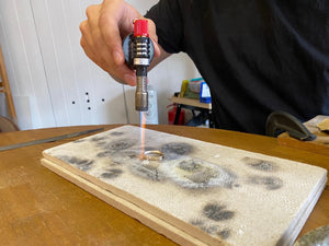 Wedding band being blowtorched by student in jewellery making workshop class