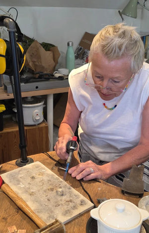 Student blowtorching silver fidget spinner ring in jewellery making workshop course