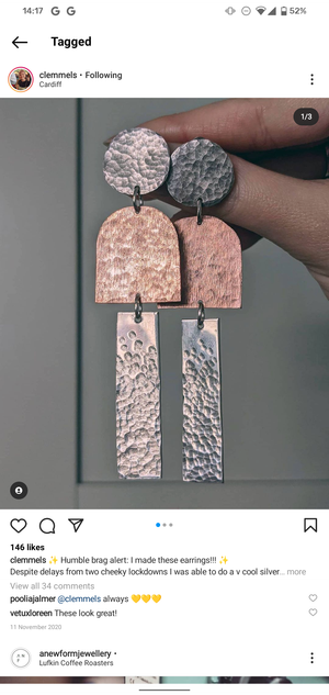 Student holding silver and copper earrings hand created in jewellery making workshop