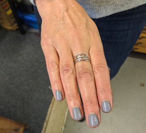 Student wears their handmade silver and copper stacking rings made in jewellery making workshop