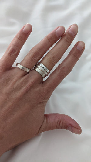 Student wears collection of handmade silver rings made in jewellery making workshop