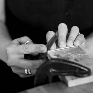 Student uses file to shape and smooth unique piece made in silver jewellery making workshop