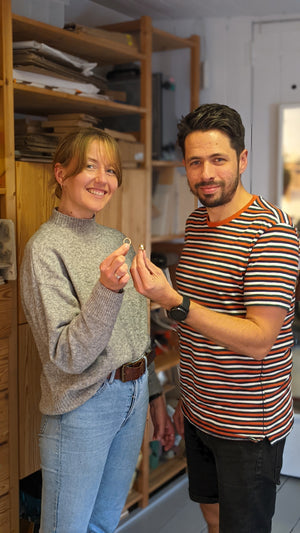 Happy couple show handmade wedding ring bands made in private workshop